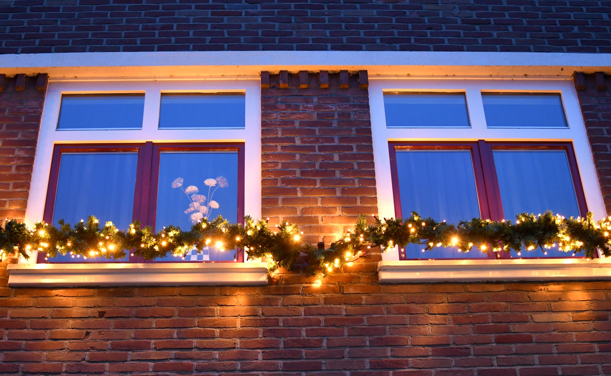guirlande met kerstlampjes onder het raam